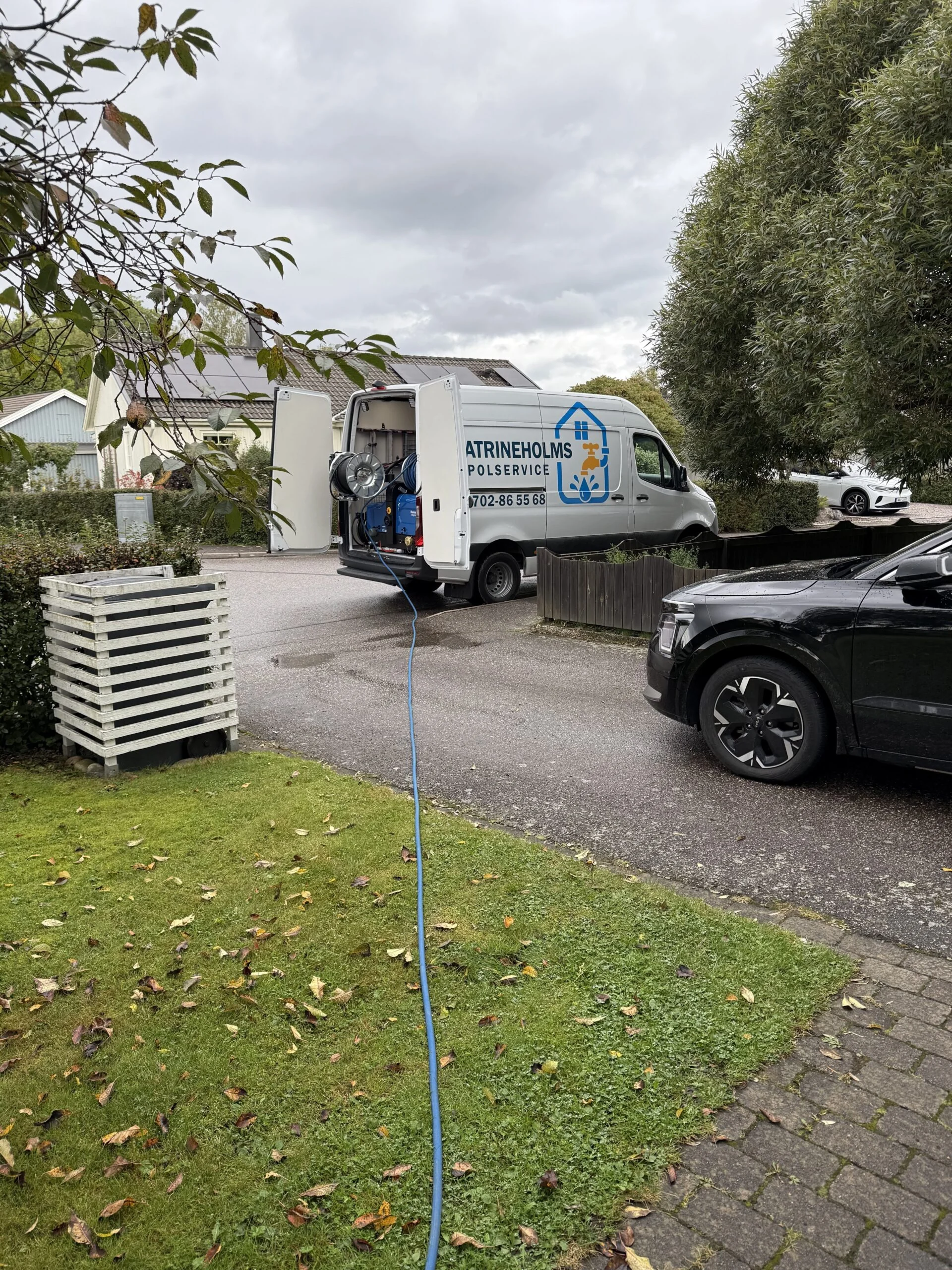 Spolslangen dragen från servicebilen till en villa